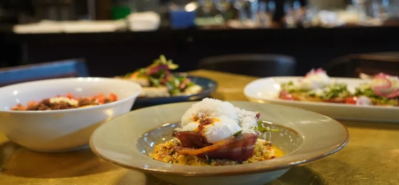 Weekend brunch at notable - The Steakhouse: crisp back bacon and a fried egg over potato hash with arugula and brown butter hollandaise